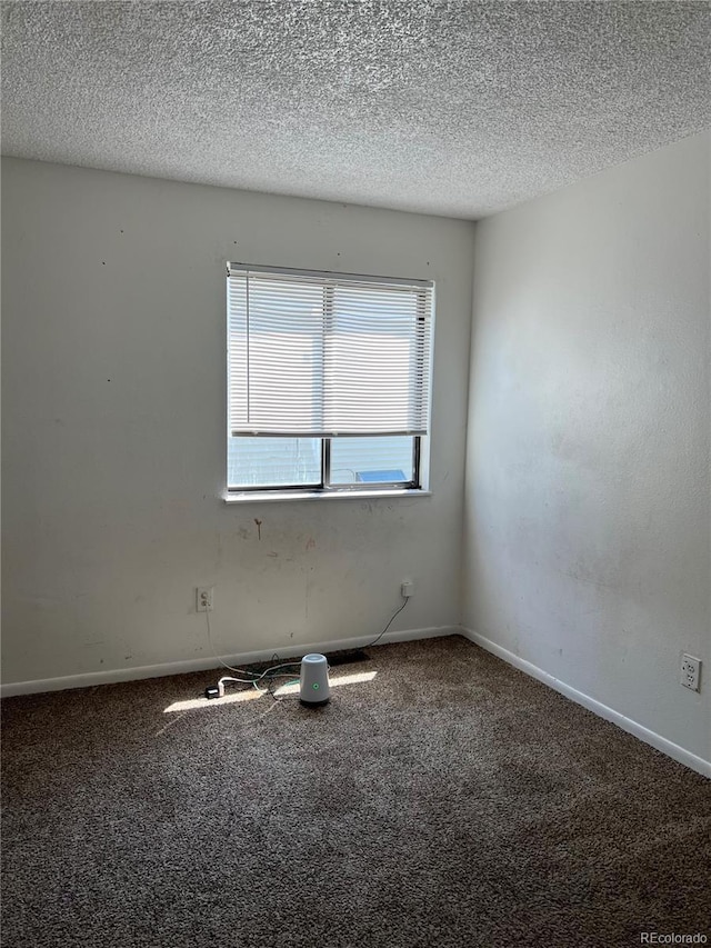 carpeted empty room featuring a textured ceiling