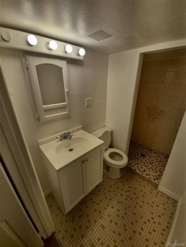 14190 E Gunnison Pl, Aurora, CO 80012 - bathroom with vanity, toilet, tiled shower, and a textured ceiling
