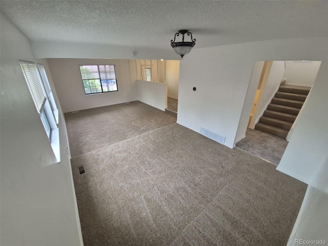 14190 E Gunnison Pl, Aurora, CO 80012 - unfurnished living room with carpet floors, stairs, and a textured ceiling