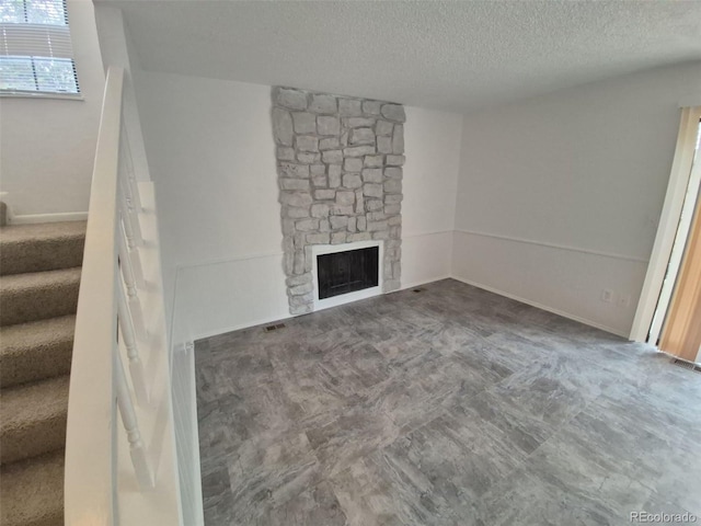 14190 E Gunnison Pl, Aurora, CO 80012 - unfurnished living room featuring a textured ceiling, stairway, and a fireplace