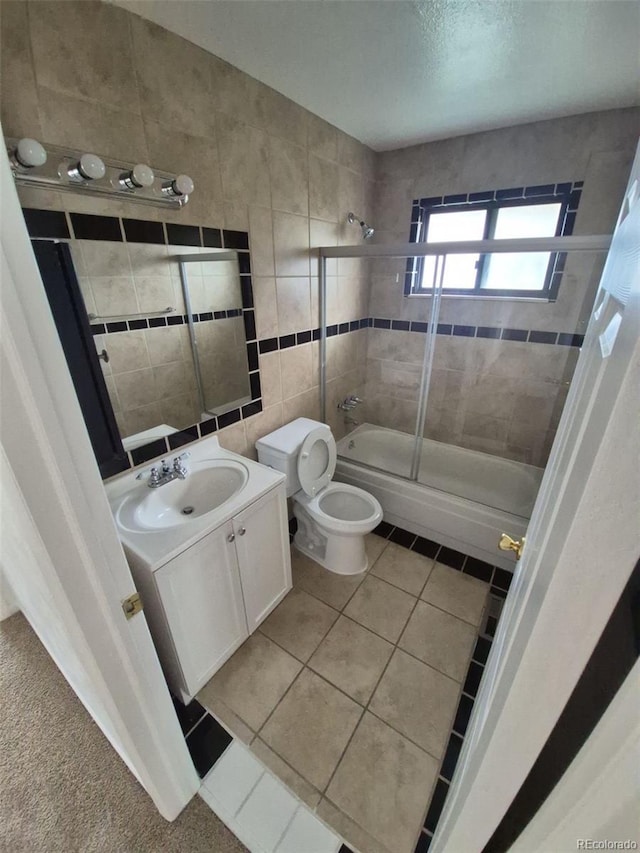 14190 E Gunnison Pl, Aurora, CO 80012 - bathroom with tub / shower combination, toilet, vanity, tile patterned floors, and tile walls