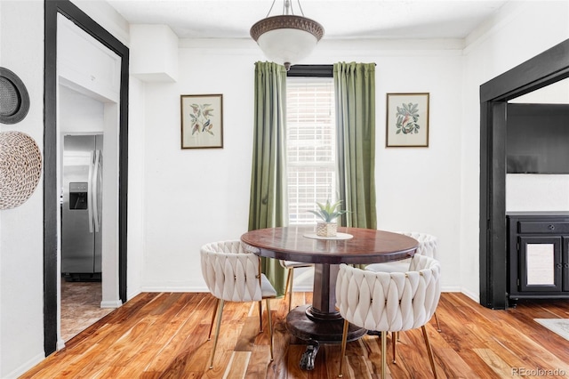 dining room featuring baseboards and light wood finished floors