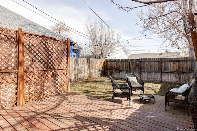 wooden deck featuring a fenced backyard and an outdoor fire pit