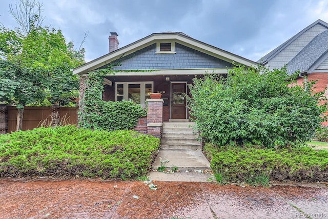 view of front of property featuring covered porch and fence