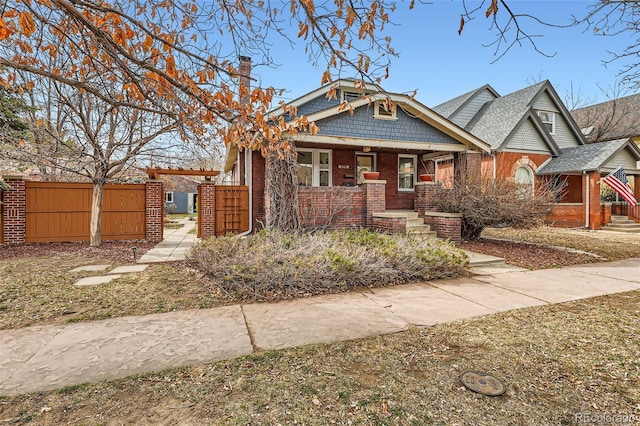 view of front of property featuring brick siding and fence