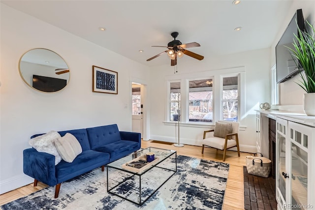living area with ceiling fan, baseboards, wood finished floors, and recessed lighting