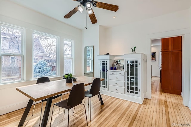 dining area with light wood finished floors and a ceiling fan