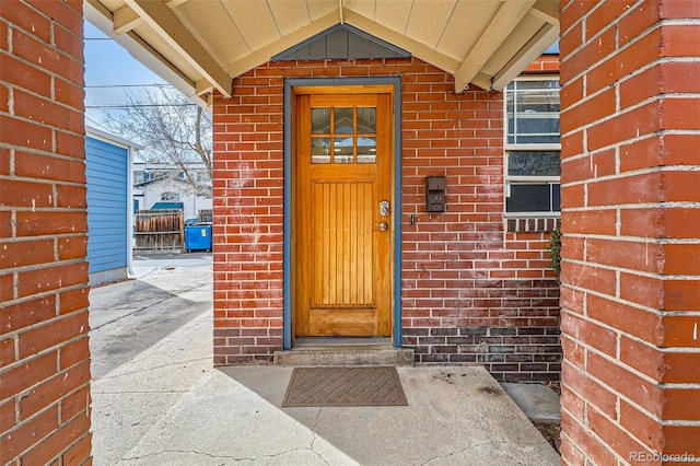 view of exterior entry featuring brick siding