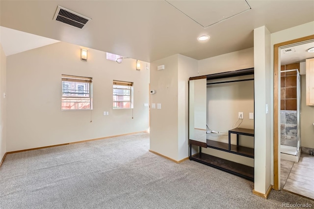 unfurnished bedroom with a closet, visible vents, carpet flooring, and baseboards