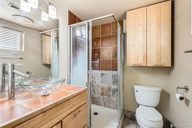 full bath with tile patterned flooring, vanity, toilet, and a stall shower
