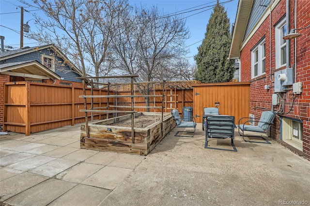 view of patio featuring a garden and a fenced backyard