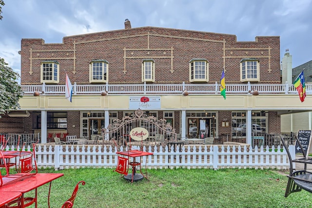 view of front of property with fence, brick siding, and a front yard