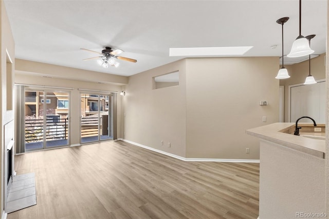 1965 Montura Vw Unit 204, Colorado Springs, CO 80919 - spare room featuring baseboards, ceiling fan, a skylight, a sink, and wood finished floors