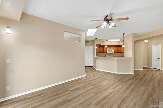 1965 Montura Vw Unit 204, Colorado Springs, CO 80919 - unfurnished living room with visible vents, baseboards, a ceiling fan, light wood finished floors, and a skylight
