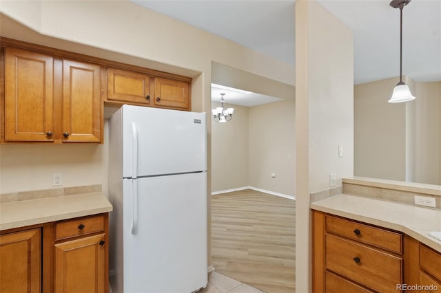 1965 Montura Vw Unit 204, Colorado Springs, CO 80919 - kitchen featuring brown cabinetry, freestanding refrigerator, and light countertops