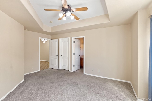 1965 Montura Vw Unit 204, Colorado Springs, CO 80919 - unfurnished bedroom featuring baseboards, a ceiling fan, a tray ceiling, connected bathroom, and carpet flooring