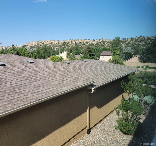 1965 Montura Vw Unit 204, Colorado Springs, CO 80919 - details with a mountain view, a shingled roof, a downspout, and gutters