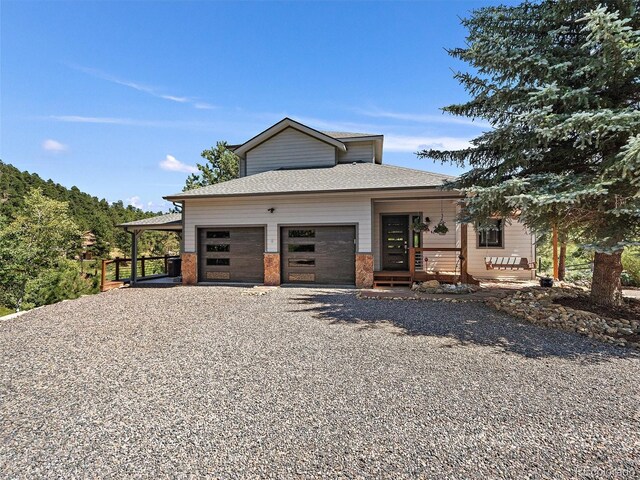 31518 Niakwa Rd, Evergreen, CO 80439 - view of front of property featuring gravel driveway, covered porch, an attached garage, and roof with shingles