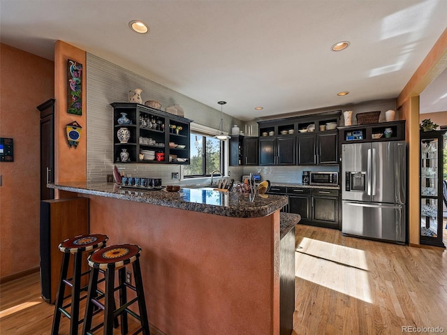 31518 Niakwa Rd, Evergreen, CO 80439 - kitchen with appliances with stainless steel finishes, dark cabinetry, light wood-style floors, decorative backsplash, and recessed lighting