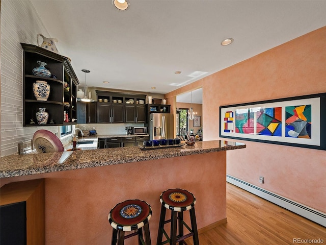 31518 Niakwa Rd, Evergreen, CO 80439 - kitchen with appliances with stainless steel finishes, a baseboard heating unit, a sink, a peninsula, and open shelves