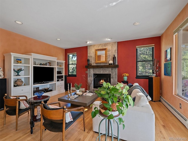 31518 Niakwa Rd, Evergreen, CO 80439 - living room with a baseboard radiator, wood finished floors, a tiled fireplace, and recessed lighting
