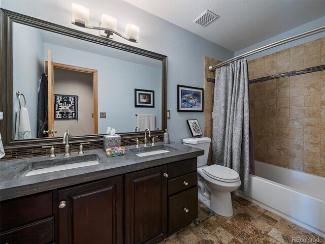 31518 Niakwa Rd, Evergreen, CO 80439 - bathroom with toilet, double vanity, shower / bathtub combination with curtain, and stone finish flooring