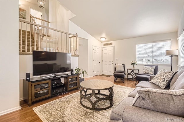 living room with wood-type flooring and vaulted ceiling