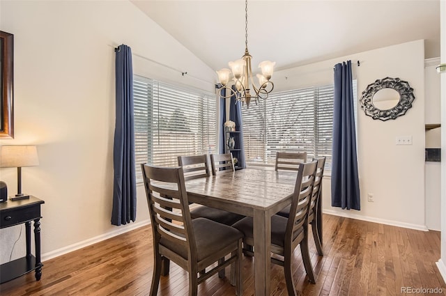 dining space featuring hardwood / wood-style flooring, vaulted ceiling, and a wealth of natural light