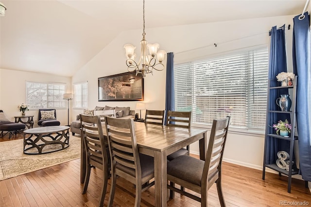 dining area featuring a chandelier, hardwood / wood-style flooring, vaulted ceiling, and plenty of natural light