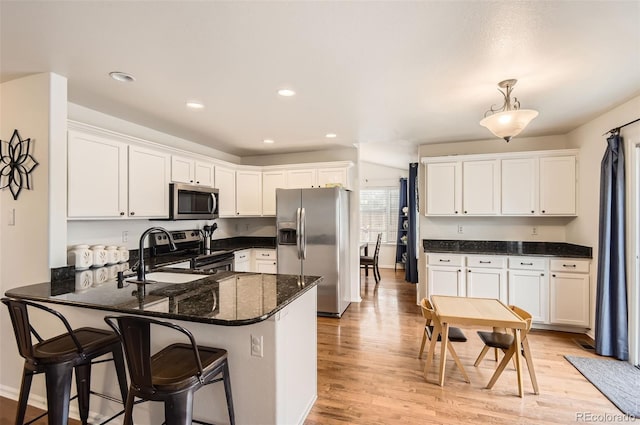 kitchen featuring kitchen peninsula, white cabinetry, stainless steel appliances, and decorative light fixtures