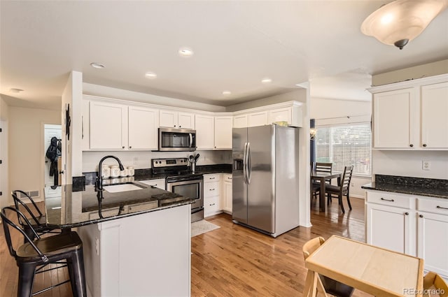 kitchen featuring kitchen peninsula, appliances with stainless steel finishes, white cabinetry, and sink