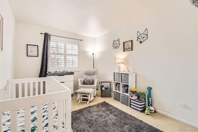 bedroom featuring a crib and carpet floors