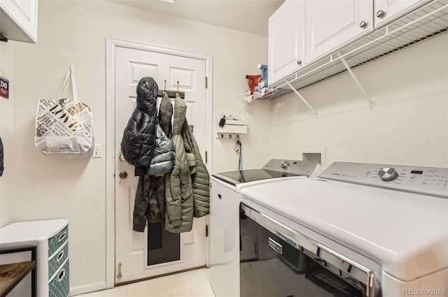 laundry room featuring washer and dryer and cabinets