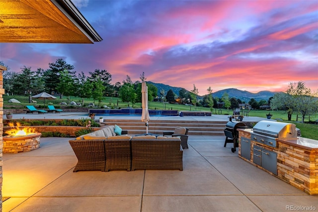 5727 Colorow Dr, Morrison, CO 80465 - view of patio / terrace with a mountain view, a swimming pool, and an outdoor living space with a fire pit