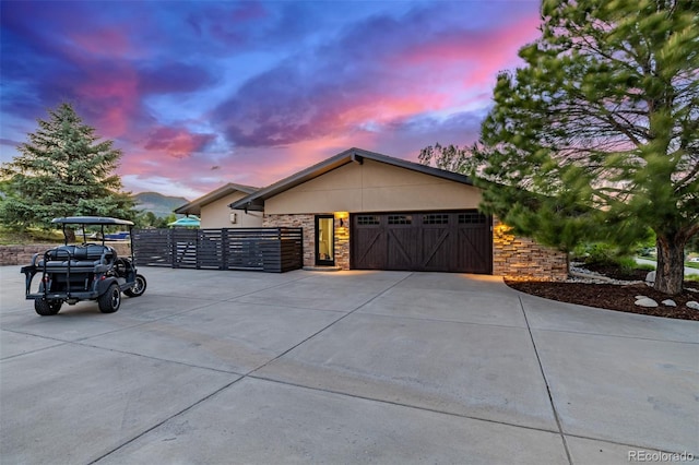 5727 Colorow Dr, Morrison, CO 80465 - view of front facade with a garage, stone siding, concrete driveway, and a gate