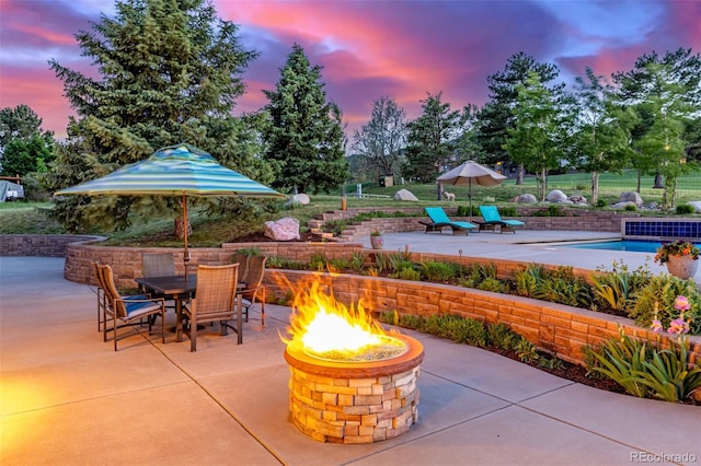 5727 Colorow Dr, Morrison, CO 80465 - patio terrace at dusk with an outdoor fire pit, a patio, and outdoor dining area