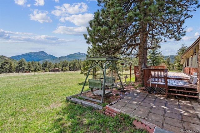 view of yard with a deck with mountain view