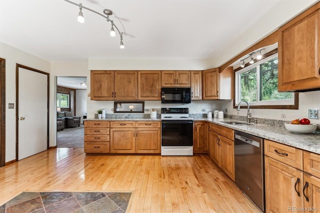 kitchen featuring stainless steel dishwasher, brown cabinetry, a sink, black microwave, and electric stove