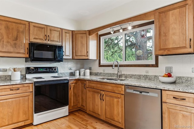kitchen featuring range with electric stovetop, black microwave, stainless steel dishwasher, a sink, and light wood finished floors
