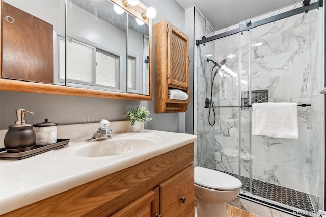 full bath with a marble finish shower, vanity, and toilet