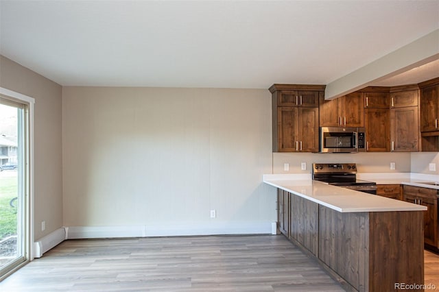 1153 Straight Creek Dr Unit F102, Dillon, CO 80435 - kitchen featuring range with electric stovetop, stainless steel microwave, light wood-style floors, baseboards, and light countertops