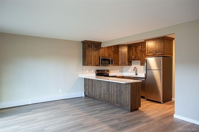 1153 Straight Creek Dr Unit F102, Dillon, CO 80435 - kitchen with stainless steel appliances, a sink, a peninsula, and baseboards