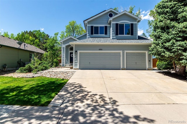 view of front of home with a garage, driveway, a shingled roof, and a front yard