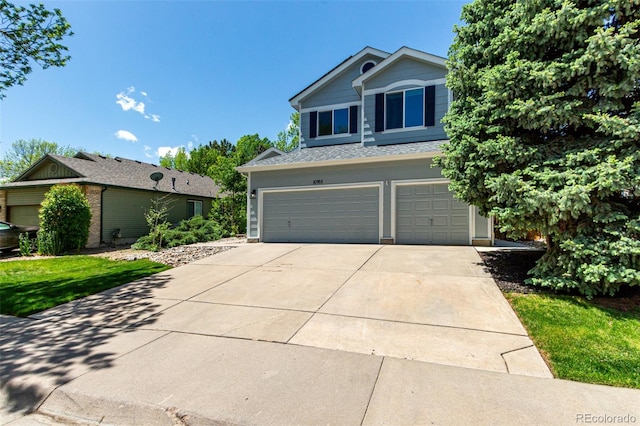 view of front of home with a garage, driveway, and a shingled roof