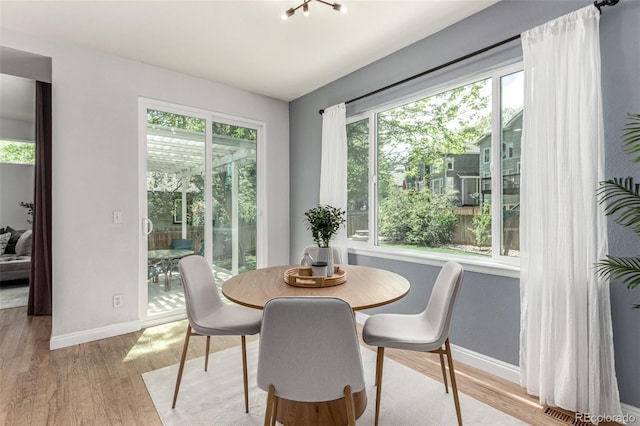 dining space featuring baseboards and light wood-type flooring