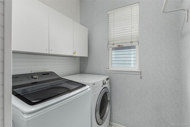 laundry room with independent washer and dryer and cabinet space