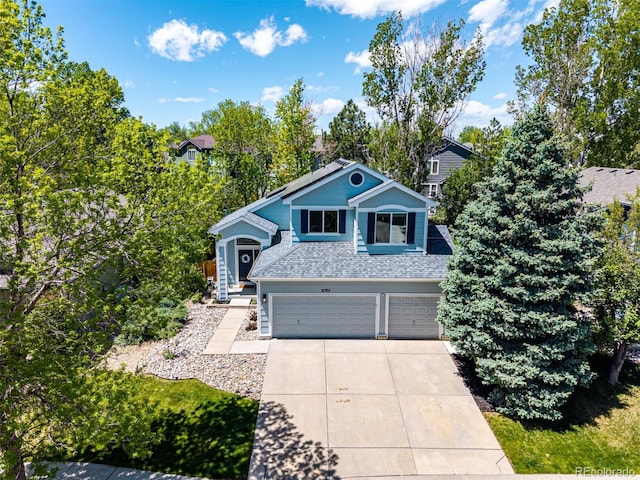 view of front of property with a garage, concrete driveway, and roof with shingles