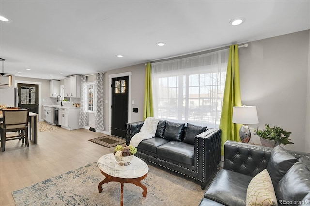 living room featuring sink and light hardwood / wood-style floors