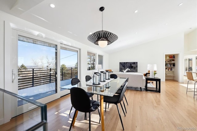 dining area featuring vaulted ceiling and light hardwood / wood-style flooring