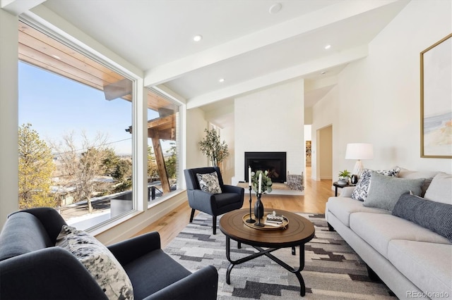 living room with beamed ceiling, a fireplace, and hardwood / wood-style floors